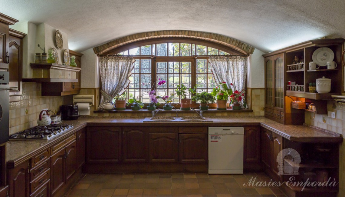 View of the kitchen of the house with a spectacular window overlooking the garden