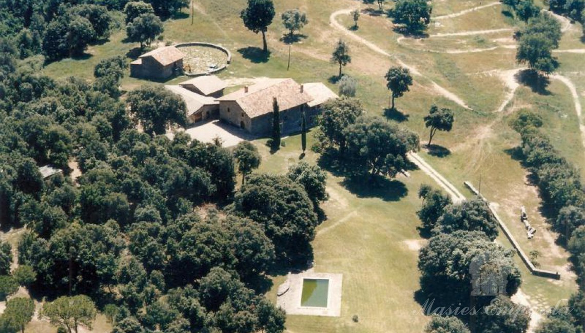 Aerial view of the construction complex of the farmhouse surrounded by the garden