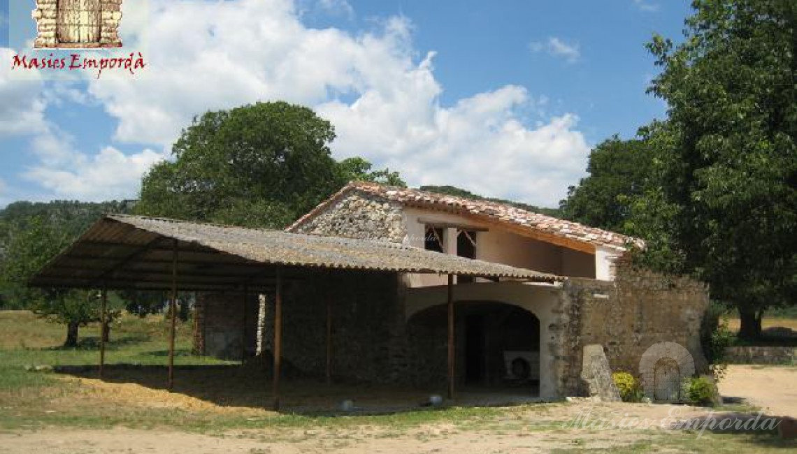 Fachada de la construcción anexa a la masía con un gran porche frontal 