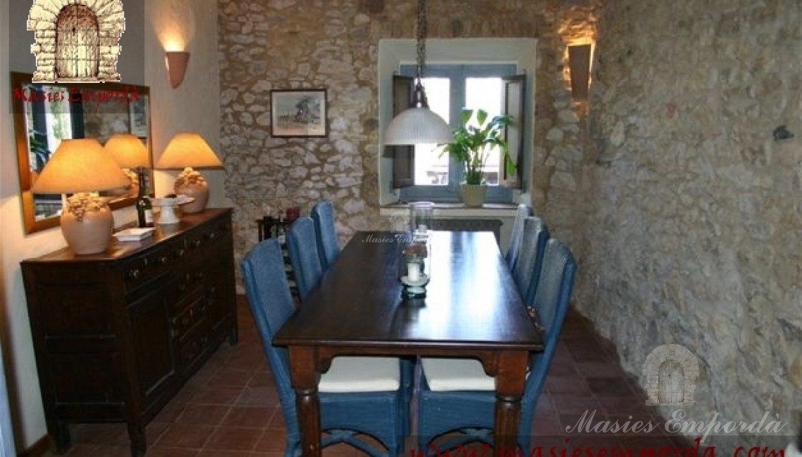 Comedor en salón abovedado y paredes de piedra