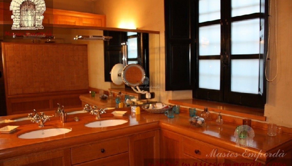 Detalle del baño de la suite con ventanal al jardín y gran espejo 