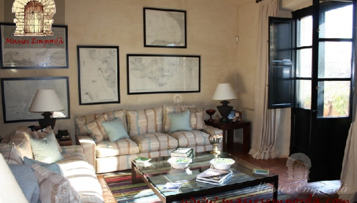Vista desde otro ángulo del salón principal de la casa donde se aprecian el conjunto de los sofás que la decoran y la salida directamente al jardín 
