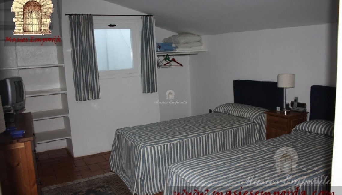 Otra habitación de la casa con dos camas individuales y cubierta abuhardillada 