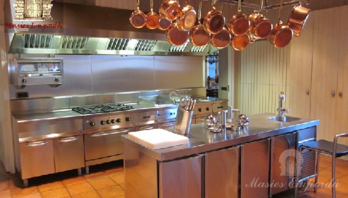 Vista lateral de la cocina con equipamiento profesional toda ella en acero inoxidable 