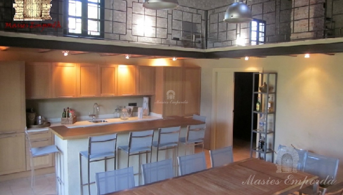 Pabellón de verano con el comedor y la cocina en primer término y parte de la planta