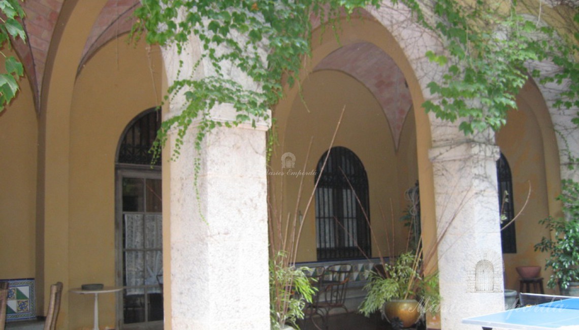 Porche corrido en fachada sur de la propiedad con arcos de crucería 