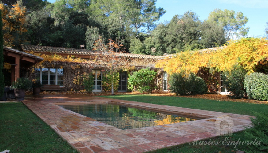 Piscina de la casa rodeada por el jardín. 