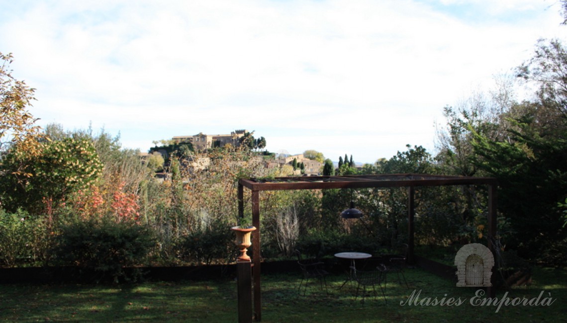 Pérgola del jardín con mesas y sillas de forja  