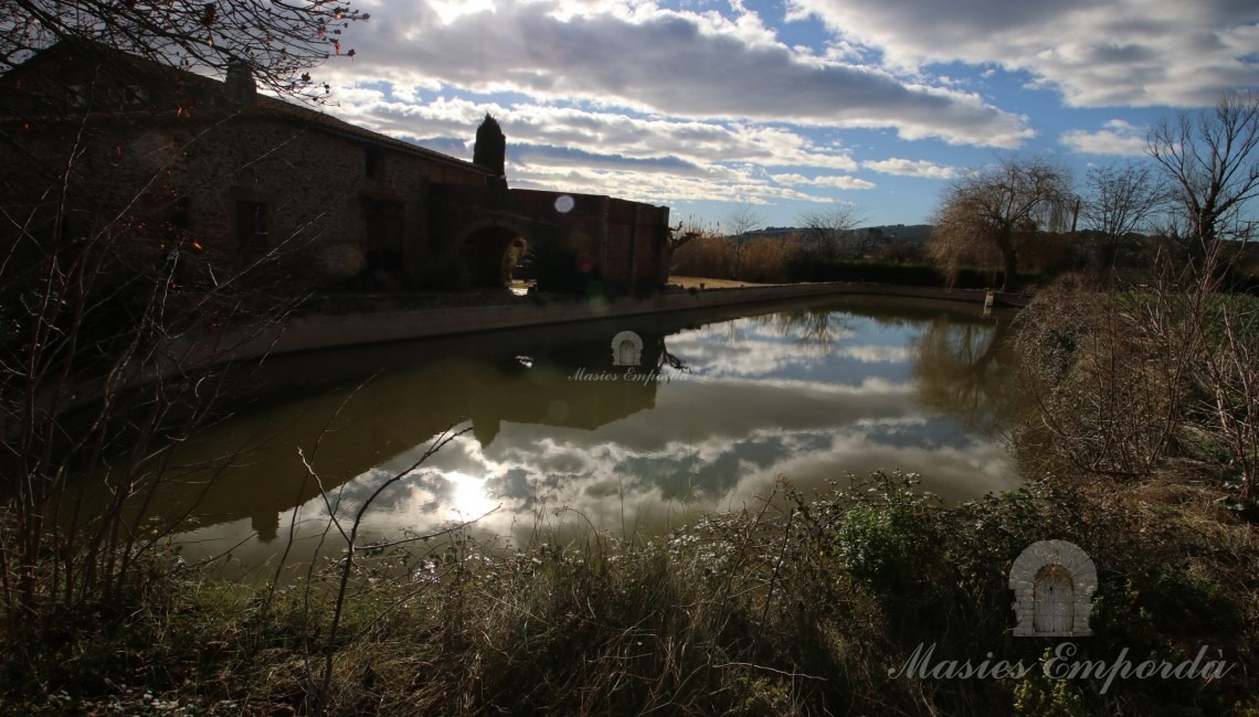 Views of the pond and the side façade of the farmhouse