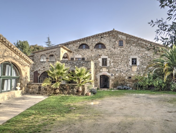Vista frontal de la frachada de la Masía con la cubierta a dos aguas y anexo adjunto a la fachada. 