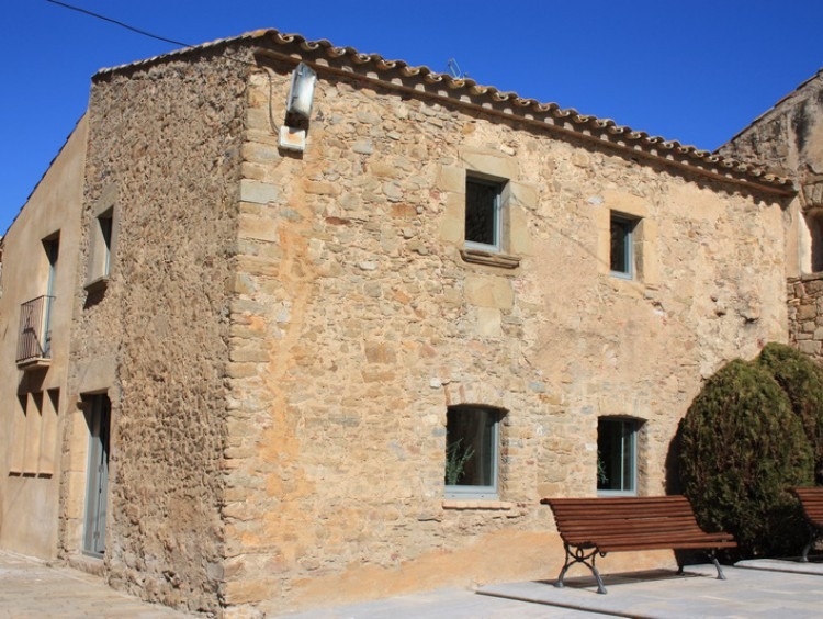 Vista de la fachada y el lateral de la casa de pueblo  