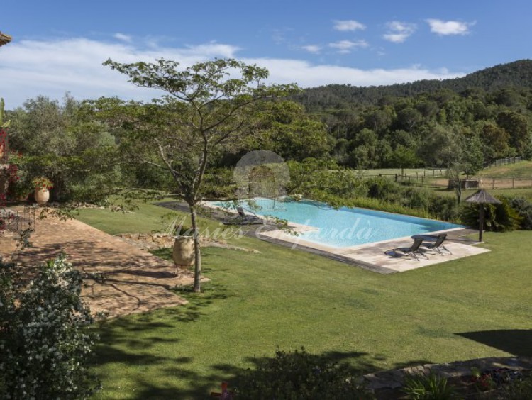 Vista de la piscina el jardín y parte de las montañas que rodean la propiedad