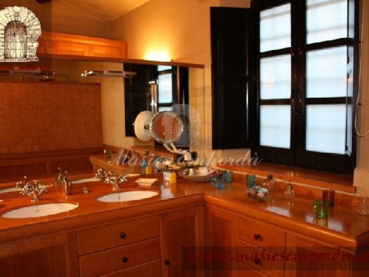 Detalle del baño de la suite con ventanal al jardín y gran espejo 