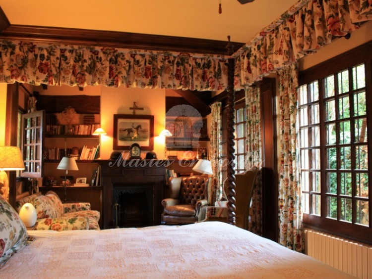 Detalle de la suite principal con chimenea al fondo con vistas al dosel de la cama