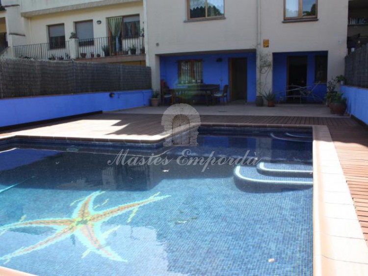 Vista de la piscina y de la casa al fondo de la imagen
