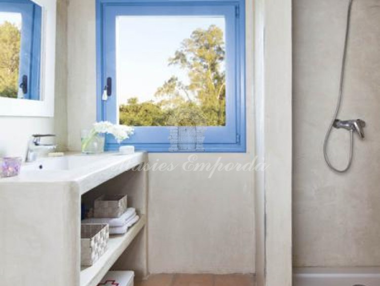 Baño completo con ducha con ventana con marco azul la banda
